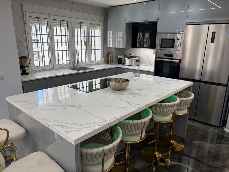 Cocina con isla mármol y taburetes en Sevilla