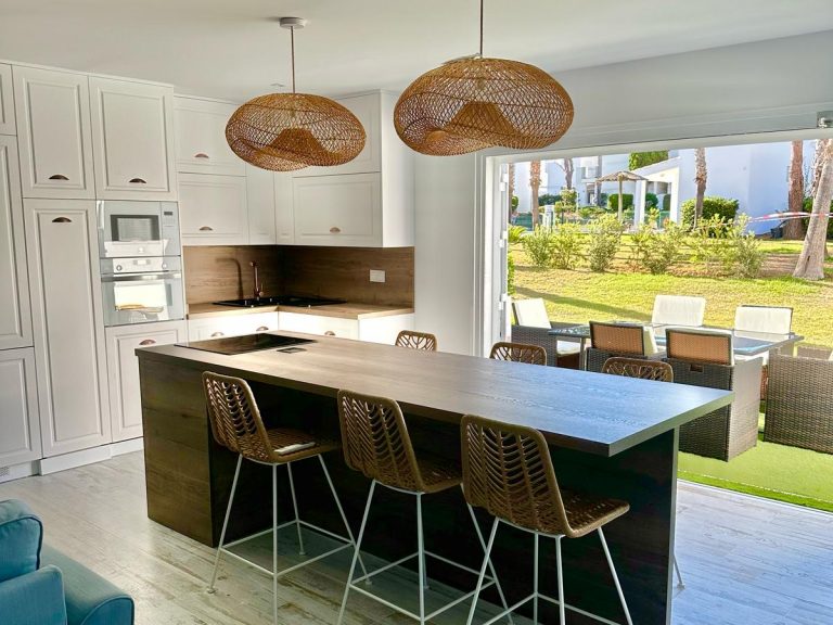 Cocina con isla verde y vistas al jardín Sevilla