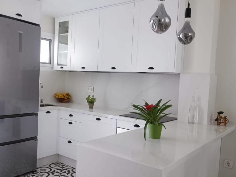 Cocina blanca luminosa con isla en Sevilla